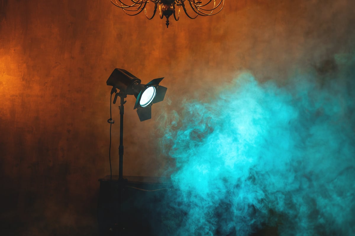 Dramatic studio spotlight breaking through hazy dark air, a cinema light cue